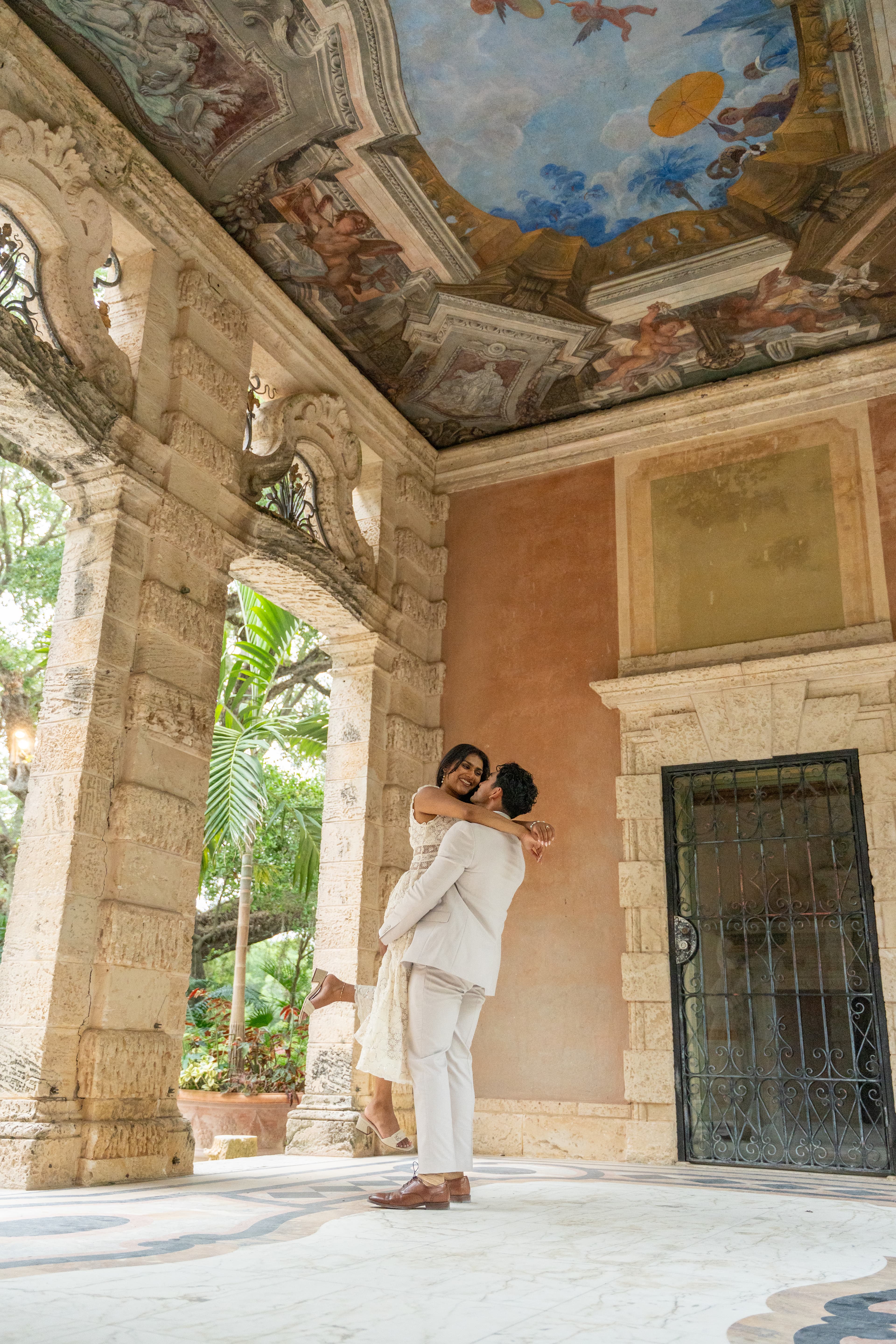 Pooja and Yash standing in front of a piano.